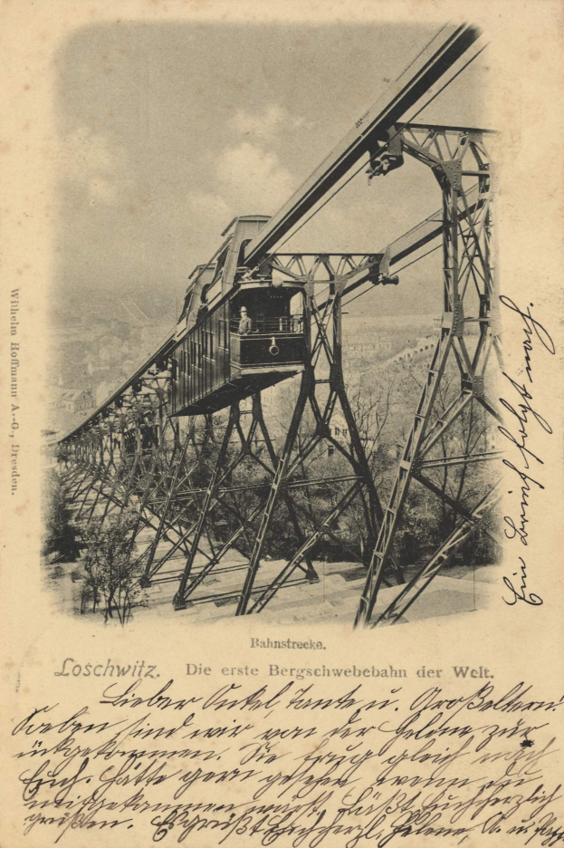 Ein altes Schwarz-Weiß-Foto einer Eisenbahnbrücke mit einem Kran, umgeben von Bäumen und einem bewölkten Himmel, mit dem Text "Bahnstrecka, die erste Eisenbahnbrücke in Deutschland" unten.