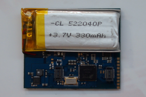 Nahaufnahme einer Handy-Batterie auf einer Platine mit aufgedrucktem Text, die auf einer weißen Oberfläche liegt.