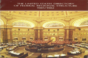 Einblicke in das United States Directory of Federal Regional Structure 1981/1982, das einen Raum mit Tischen zeigt, die mit Papieren und Gegenständen bedeckt sind, sowie Säulen und Bögen im Hintergrund und Text oben auf dem Bild.