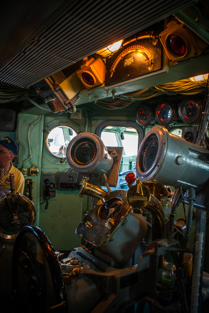 Das Innere eines Zuges mit Sitzen und verschiedenen Gegenständen, eine Person in einem gelben T-Shirt steht auf der linken Seite.