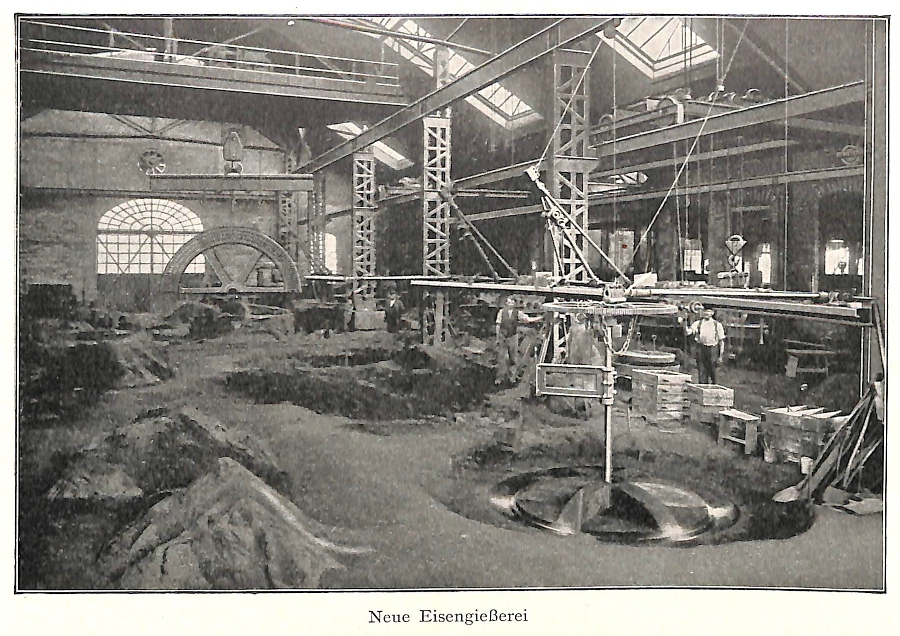 Schwarz-weißes Foto eines Fabrikinneren mit Arbeitern, die Maschinen bedienen, Metallstangen und -stäbe, beschriftet mit "Neue Eisenglebeerei, die erste Fabrik in Deutschland" unten.