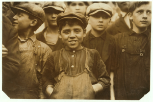 Schwarzes und weißes Foto einer Gruppe junger Jungen, die nebeneinander stehen und alle eine Mütze tragen.