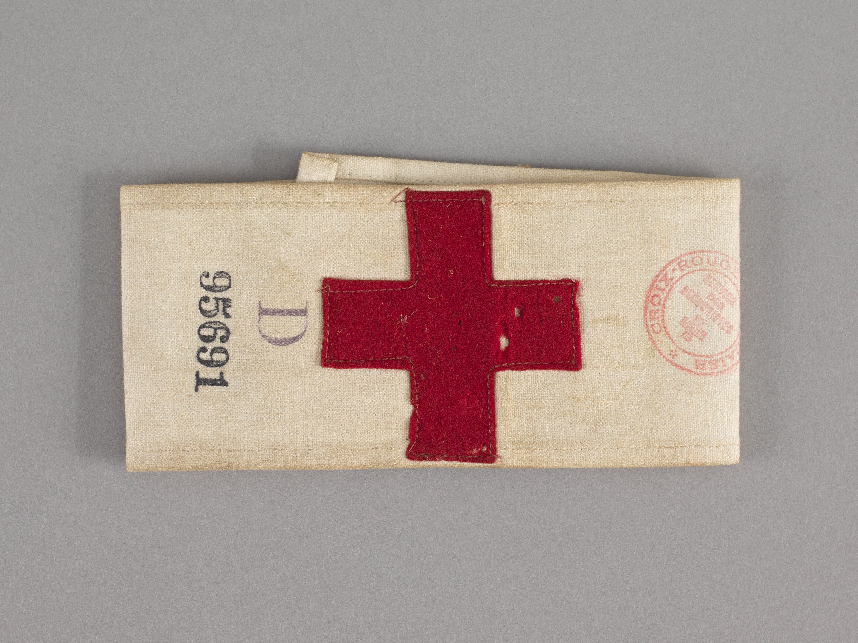 Ein rotes Kreuz markierter Verbandskasten in einer Stofftasche auf einer Oberfläche.
