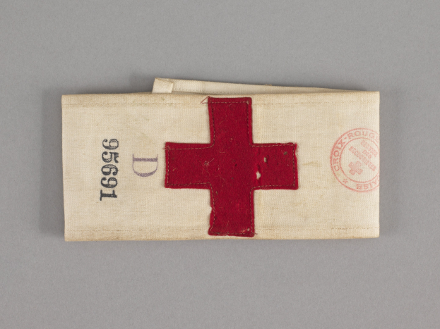 Ein rotes Kreuz markierter Verbandskasten in einer Stofftasche auf einer Oberfläche.