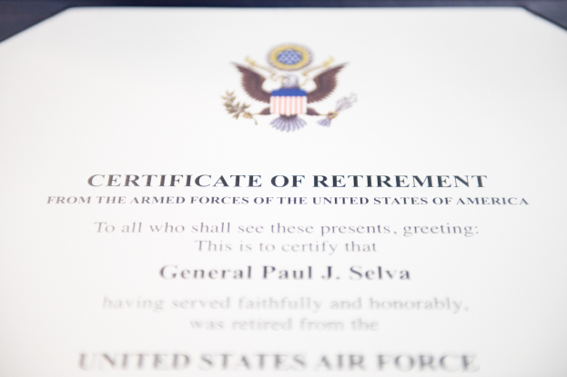 Rahmenurkunde der United States Air Force mit blauer Einfassung, zentralem Sternschild-Logo, umgeben von einem Lorbeerkranz und einer "Retirement"-Banderole, alles in Schwarz gedruckt.